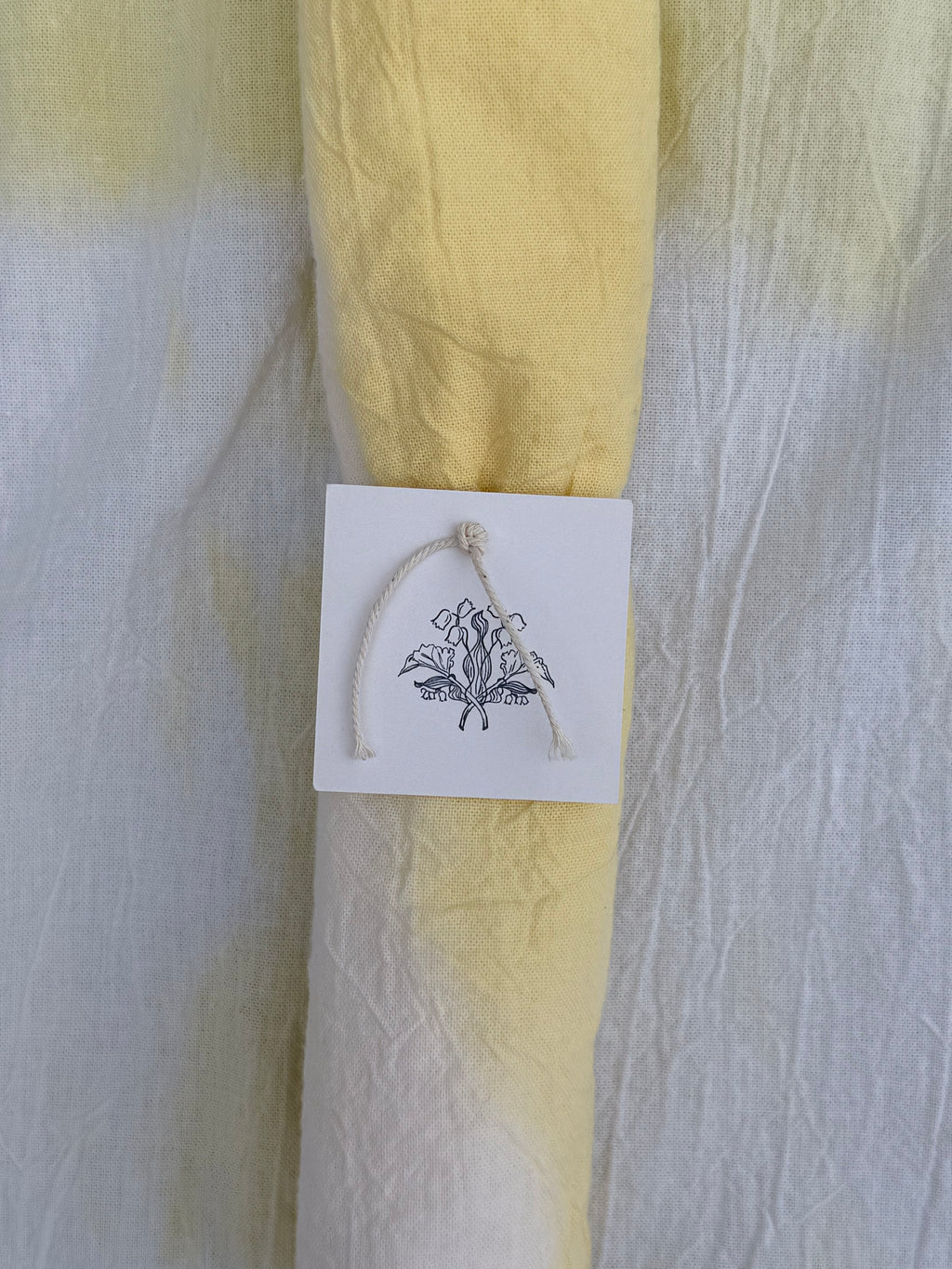 Natural dyed cotton fabric with a white tag featuring 