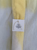 Natural dyed cotton fabric with a white tag featuring 
