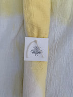 Natural dyed cotton fabric with a white tag featuring 