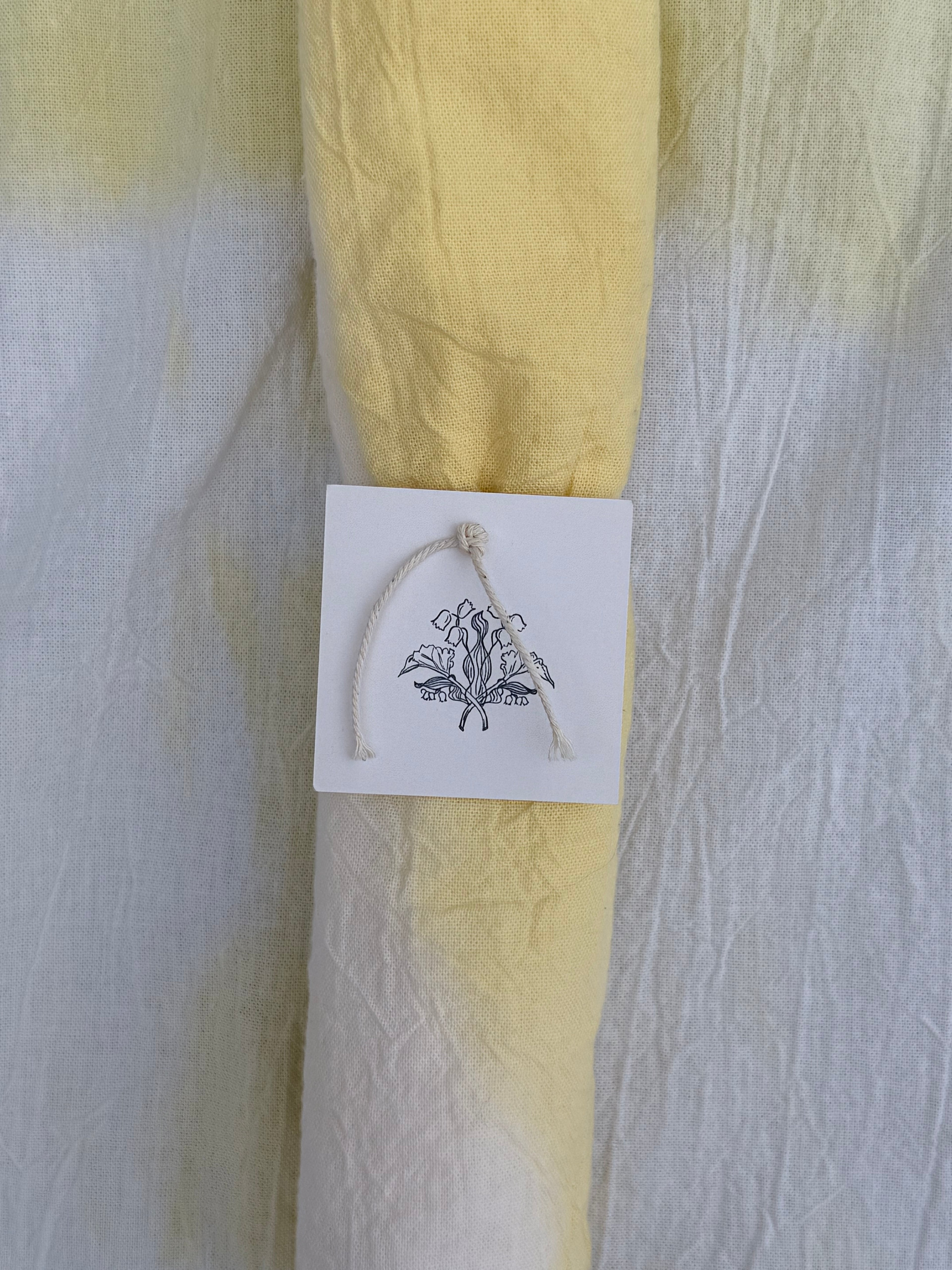 Natural dyed cotton fabric with a white tag featuring 
